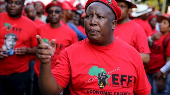 Лидер южноафриканских борцов за экономическую свободу (EFF) Джулиус Малема жестами после прибытия на Йоханнесбургскую фондовую биржу (JSE) в Сэндтоне