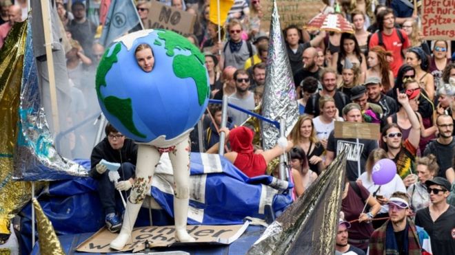 Один демонстрант одевается как глобус в Гамбурге