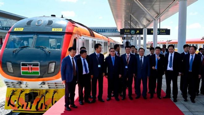 Китайские официальные лица позируют фотографу при запуске пассажирского поезда стандартной колеи (SGR) из Найроби в Сусву в октябре 2019 года