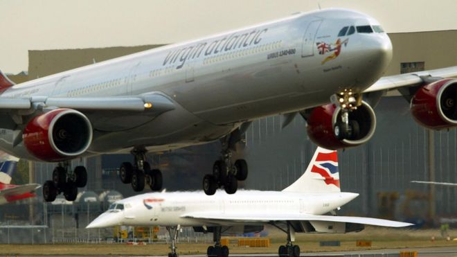 Конкорд ждет взлета, когда самолет Virgin Atlantic заходит в лондонский аэропорт Хитроу 24 октября 2003 года.