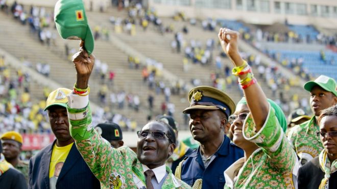 Роберт Мугабе (слева) и его жена Грейс (справа) приветствуют сторонников после своего выступления на митинге в Хараре 28 июля 2013 года