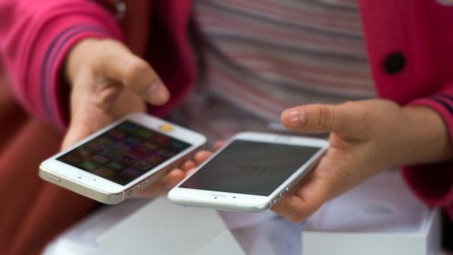 Женщина сравнивает новый айфон 6 со своим старым 5s, Шанхай, октябрь 2014 года.