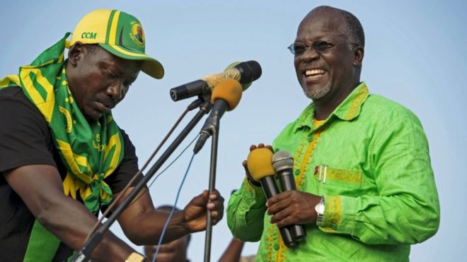 Кандидат в президенты Джон Магуфули смеется, когда во время правящей акции Chama Cha Mapinduzi (CCM) в Дар-эс-Саламе, Танзания, 21 октября 2015 года, установлены микрофоны