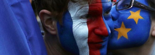 Сторонники избранного президента Франции Эммануэля Макрона, расписанные флагами Франции и ЕС, празднуют в Лувре в Париже 7 мая 2017 года, после второго тура президентских выборов во Франции
