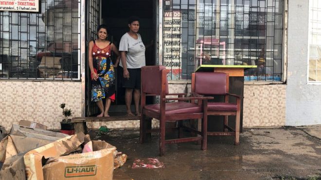 Владельцы бизнеса в их собственности после наводнения от тропического циклона Джози на Фиджи