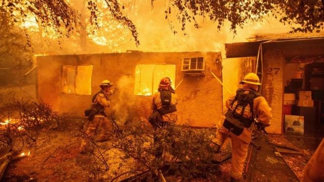 Пожарные борются с огнем в раю, штат Калифорния.