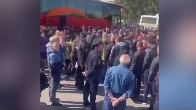 Russian men waiting to board bus