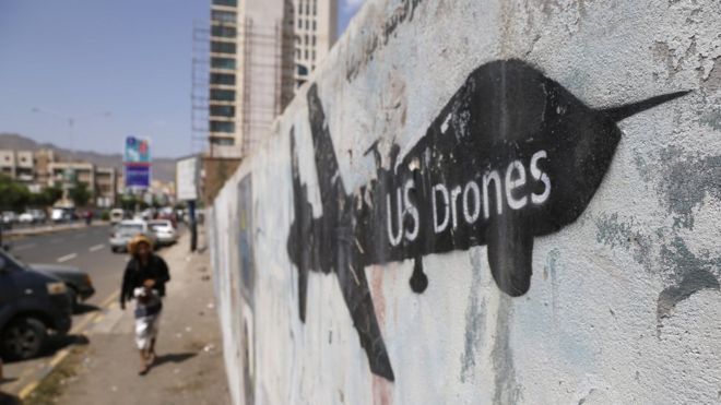 Йеменец смотрит на граффити в знак протеста против ударов американских беспилотников 19 сентября 2018 года