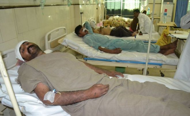 Pakistani men rest in hospital after an attack on a Sufi shrine