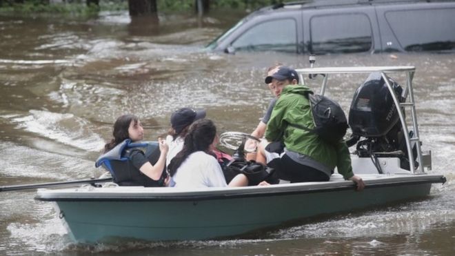 Volunteers and officers from a Houston neighbourhood security patrol help rescue residents in River Oaks (27 August 2017)