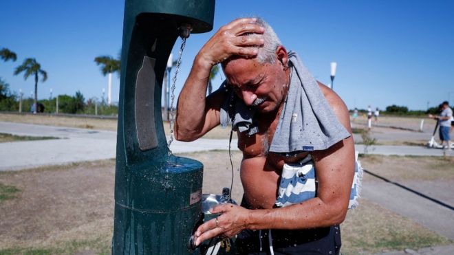 Hombre en Argentina mojándose la cabeza bajo una canilla