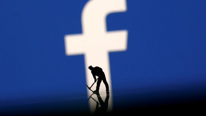 A figurine is seen in front of the Facebook logo in this illustration taken, 20 March 2018