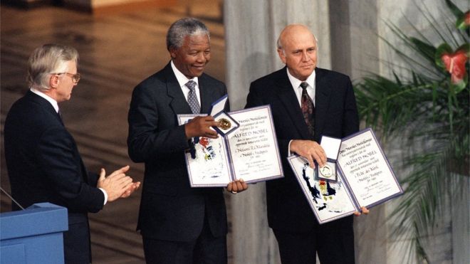 Нельсон Мандела, президент Южно-Африканского национального конгресса (C) и президент Южной Африки Фредерик де Клерк (R) демонстрируют 09 декабря 1993 года в Осло свои Нобелевские премии после совместного присуждения за их работу по мирному искоренению апартеида.