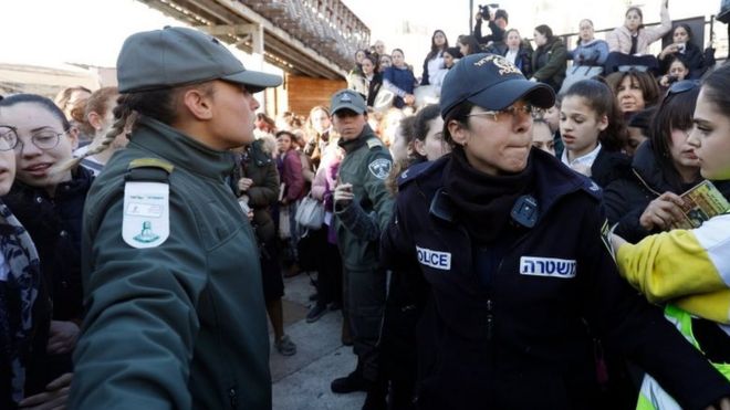 Израильские женщины-полицейские удерживают 8 марта 2019 года ультра-ортодоксальные еврейские девушки, собравшиеся на святыне иудаизма у Западной стены в Старом городе Иерусалима