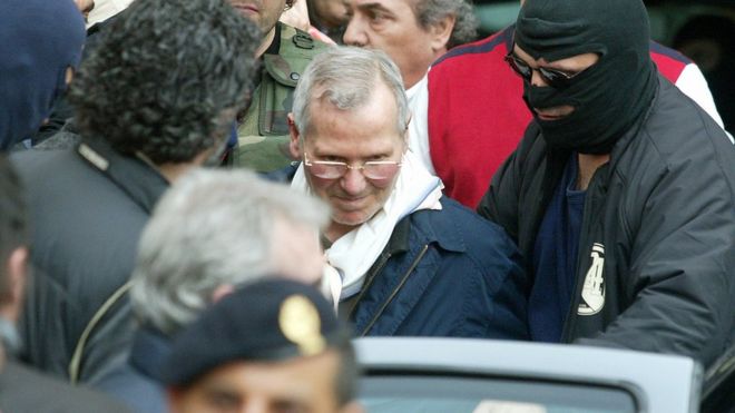 Босс мафии Бернардо Провенцано с полицейскими в капюшонах после его захвата в Палермо, Сицилия, южная Италия, 11 апреля 2006 г.