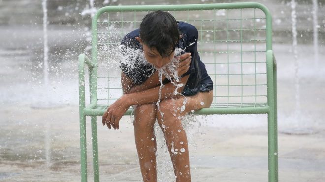 Молодой албанец отдыхает после игры в фонтане во время сильной жары на главной площади в Тиране, Албания, 3 августа 2017 года