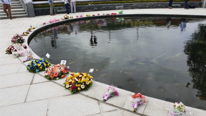 Цветочные дани помещены в мемориальный сад бомбы Ома