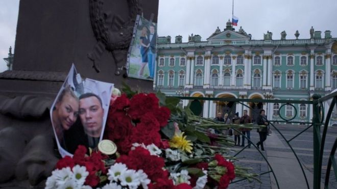 Цветочная ложь рядом с фотографиями жертв авиакатастрофы в Санкт-Петербурге. Фото: 2 ноября 2015 г.
