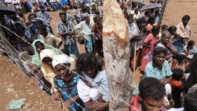 На внутренне перемещенных лиц из Шри-Ланки наблюдают во время визита Генерального секретаря ООН Пан Ги Муна в лагерь беженцев Menik Farm в Чеддикуламе 23 мая 2009 г.