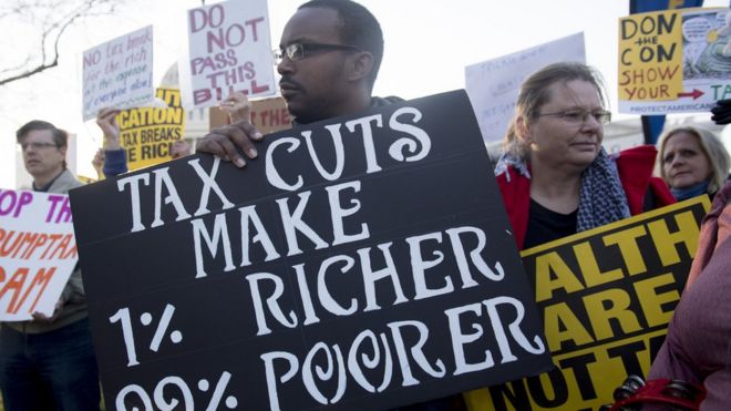 Демонстранты против республиканского законопроекта о налоговой реформе проводят акцию «Народные обидчики, чтобы остановить снижение налогов для миллиардеров», акцию протеста возле Капитолия США на Капитолийском холме в Вашингтоне, округ Колумбия, 30 ноября 2017 года.