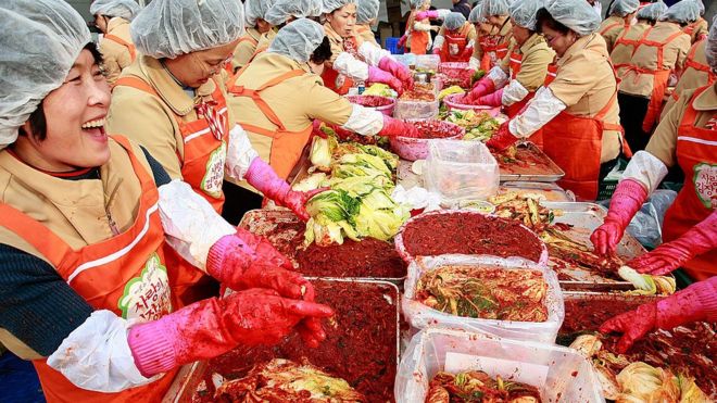 Korean women make kimchi for donation to the poor in Seoul