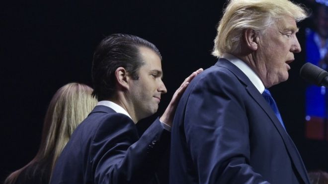 Дональд Трамп младший кладет руку на спину кандидата в президенты Дональда Трампа в последний вечер выборов в США