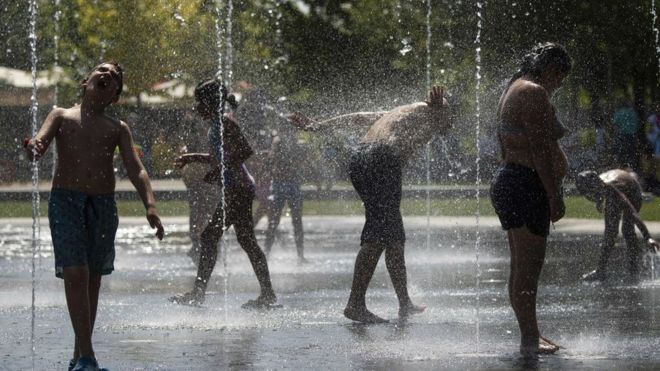 في بداية موجة حر 2019 ، أشخاص يبتردون قرب نوافير المياه في مدريد