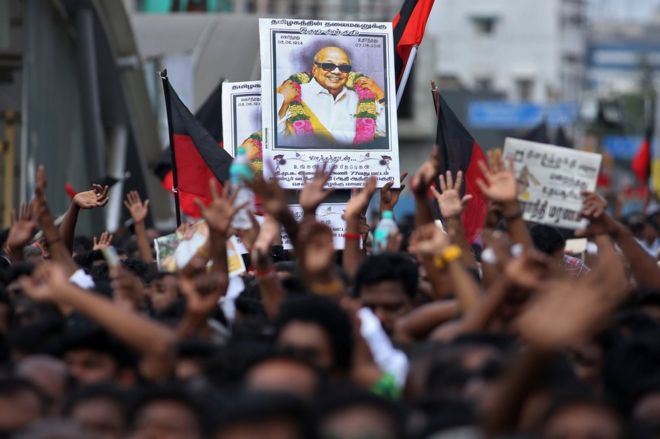 Сторонники держат портрет М. Карунанидхи во время его похорон в Ченнаи 8 августа 2018 года.
