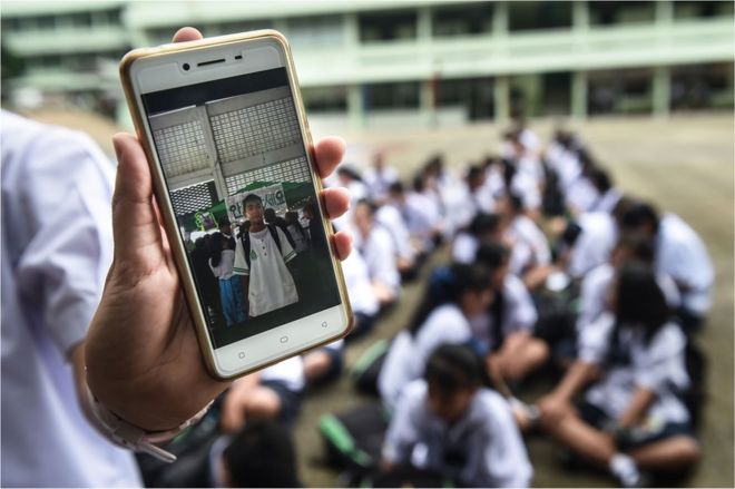 Тайский студент показывает фотографию пропавшего одноклассника Прачака Сутхэма
