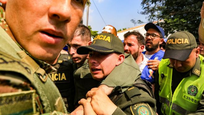 Боливарианская полиция сопровождается колумбийской полицией после того, как они дезертировали и въехали в страну за помощью