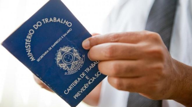 Homem segurando carteira de trabalho