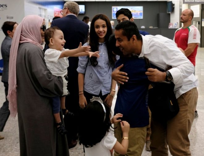 Семья обнимает друг друга в аэропорту Вашингтона имени Даллеса 26 июня 2017 года, после того как Верховный суд США удовлетворил часть чрезвычайной просьбы администрации Трампа о введении в действие запрета на поездки