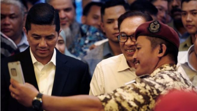 Тюремный служащий фотографирует с малазийским политиком Анваром Ибрагимом в Куала-Лумпуре, Малайзия, 16 мая 2018 года.
