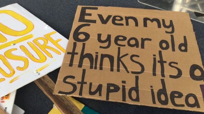 Плакат, используемый во время митинга, на котором написано, что «даже мой шестилетний ребенок думает, что это глупая идея»