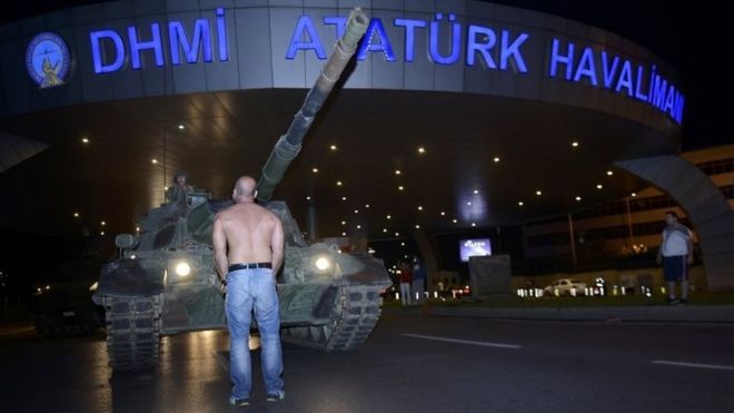 Мужчина стоит перед танком турецкой армии в аэропорту Ататюрка в Стамбуле. Фото: 16 июля 2016 г.