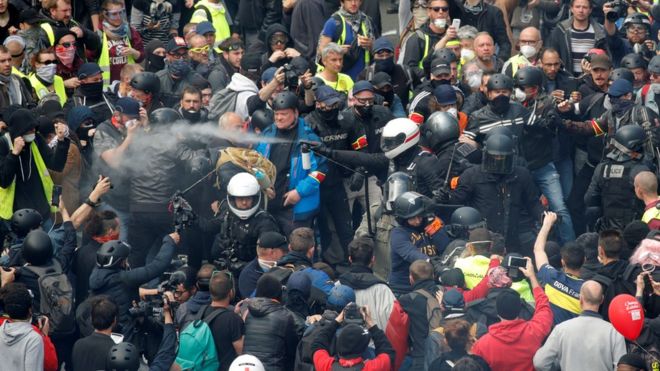 Французская полиция задерживает демонстрантов во время традиционного первомайского марша профсоюза с французскими профсоюзами и протестующими в желтых майках в Париже, Франция, 1 мая 2019 года.
