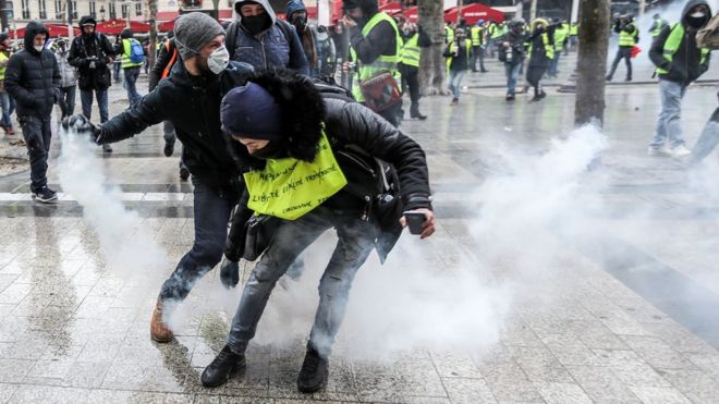 Протестующие в желтых жилетах (gilets jaunes) столкнулись с французской полицией по охране общественного порядка во время демонстрации на Елисейских полях в Париже 15 декабря.