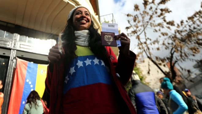Mujer muestra su pasaporte después de votar.