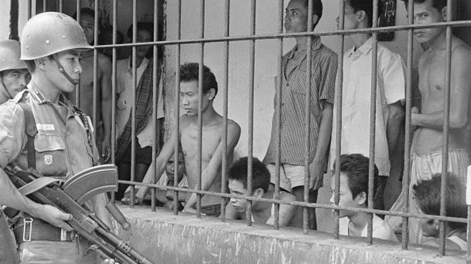 Serdadu mengawasi para tersangka Komunis yang ditahan di sebuah lokasi di Tengerang, oktober 1965