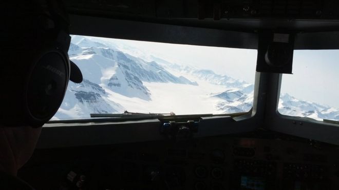 Из кабины самолета: цепь снежных гор с залитой льдом долиной между