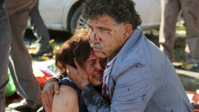 Раненый мужчина обнимает пострадавшую женщину после взрывов во время марша мира в Анкаре, Турция, 10 октября 2015 года.