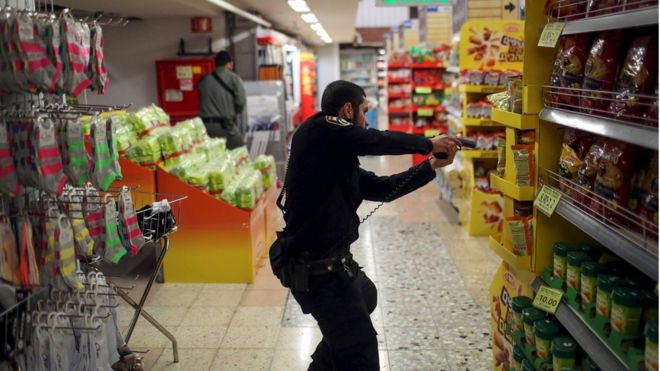 Израильский полицейский обыскивает супермаркет внутри автовокзала Центрального Иерусалима после того, как полиция сообщила, что палестинец зарезал женщину возле автобусной остановки 14 октября 2015 года.