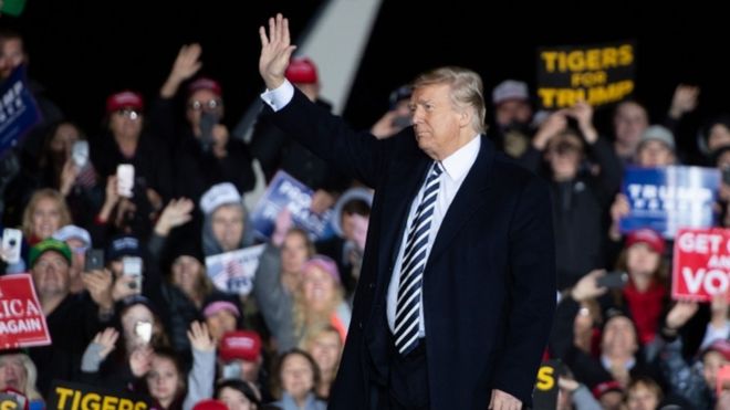 US President Donald Trump waves to supporters during a campaign rally at Columbia Regional Airport in Columbia, Missouri
