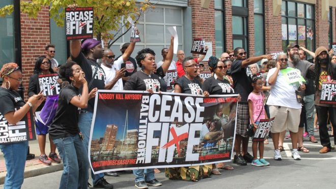 Участники марша Ceasfire движутся через центр Балтимора