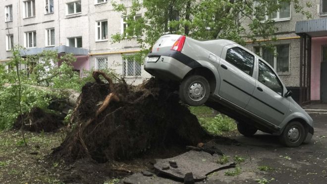 A car lifted by the roots of a tree which was toppled during a heavy storm, in Moscow. 29 May 2017