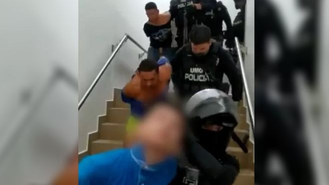 La policía conduce a unos hombres a la salida de un hospital tras su detención.