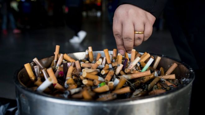 Un cenicero lleno de cigarrillos apagados.