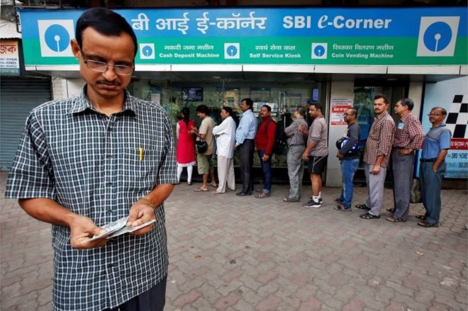 Мужчина считает банкноты в индийских рупиях, сняв их в банкомате Государственного банка Индии в Калькутте, Индия, 11 ноября 2016 года.