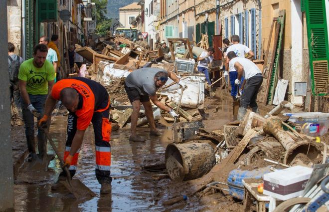 Местные жители Сан-Льорена прибираются после наводнения во вторник 11 октября