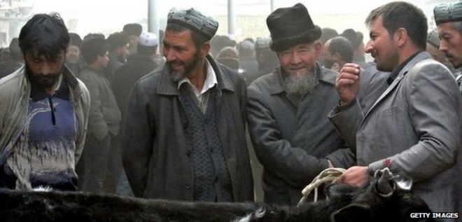 Уйгурские мужчины собираются на базаре, чтобы продать своих живых овец в регионе Синьцзян (7 ноября 2013 г.)